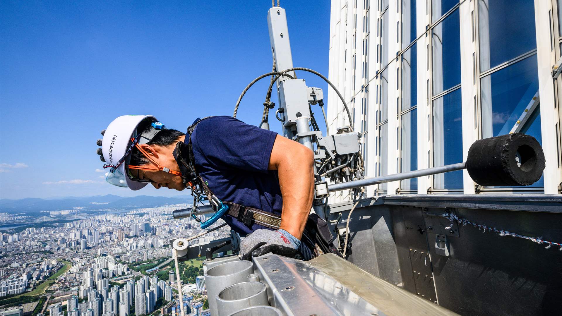 عامل تنظيف نوافذ خامس أطول برج في العالم يواجه أكبر مخاوفه: المرتفعات (صور)